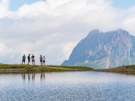 Grindpad door hoog naaldbos met een wandelaar in de verte – Rutschenwanderweg op de Wildkogel, Wildkogel Arena